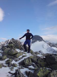 Bjørn Bye poserer på toppen av Vestre Austanbotntind. Ringstind i bakgrunnen